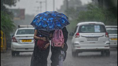Women walk under an umbrella during a shower in New Delhi last month. (File photo)