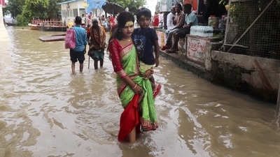 People wade through the waterlogged street as the risen water level of the Ganga river entered the road, following heavy rains, at the Assi Ghat in Varanasi. (PTI) People wade through the waterlogged street as the risen water level of the Ganga river entered the road, following heavy rains, at the Assi Ghat in Varanasi. (PTI)