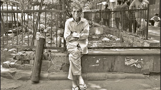 A Covid-19 patient on oxygen support waits outside LNJP Hospital for admission amid a shortage of beds, in New Delhi, in April. (HT Archive)