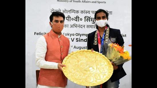 Union minister of youth affairs and sports and Hamirpur MP Anurag Thakur presenting the Chamba Thaal to Olympic medal winner PV Sindhu on her return from Tokyo recently. Chamba Thaal is a decorative brass metal plate used for rituals in Himachal Pradesh and represents the region’s metal craft. (HT Photo)