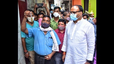 A resident of Balu Adda shows a water sample to UP law minister Brajesh Pathak. (Deepak Gupta/HT Photo)