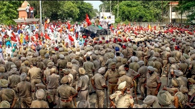 Police personnel stand guard during a protest of farm labourers against the Punjab government over their various demands in Patiala on Wednesday. (PTI)