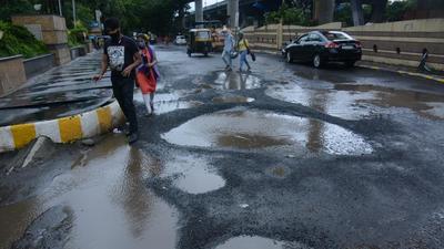Potholes on service road near Korum Mall in Thane. (HT file photo)