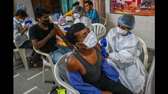 Residents get inoculated with a dose of Covaxin vaccine against the Covid-19 coronavirus at a temporary vaccination centre set up in a school in Mumbai. (AFP)