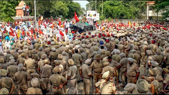 Police personnel stand guard during a protest of farm labourers against the Punjab government over their various demands in Patiala on Wednesday. (PTI)