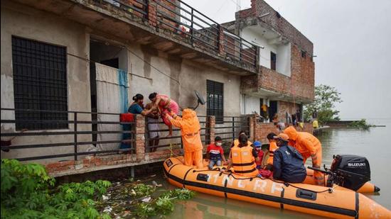 National Disaster Response Force team evacuating people from a flood-affected area at Salori in Prayagraj district of Uttar Pradesh on Wednesday. (PTI PHOTO)