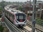 A metro train runs on a track on the Pink Line corridor. A metro train runs on a track on the Pink Line corridor.