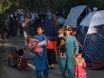 Internally-displaced Afghan families, who fled from Kunduz, Takhar and Baghlan province due to battles between Taliban and Afghan security forces, walk past their temporary tents in Kabul on August 11.