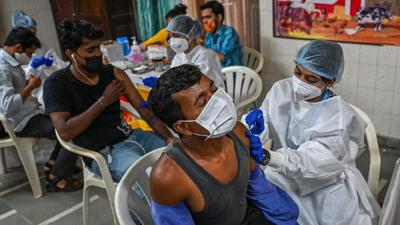 Residents get inoculated with a dose of Covid-19 vaccine at a temporary vaccination centre in Mumbai on August 10. (AFP)