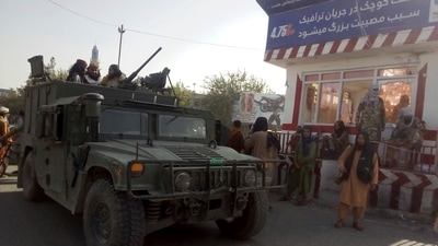 Taliban fighters stand guard at a checkpoint in Kunduz city, northern Afghanistan. (AP)