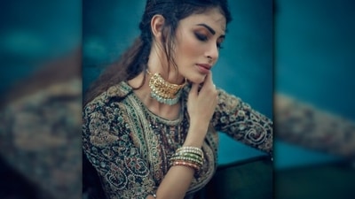 She accessorised her look with a golden choker with green stones and colourful bangles. (Instagram/@imouniroy) She accessorised her look with a golden choker with green stones and colourful bangles. (Instagram/@imouniroy)