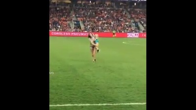 The image shows the mother carrying the toddler out of the field. (Twitter/@GeoffONeil)