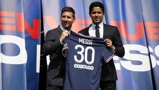 Lionel Messi del Paris Saint-Germain y el presidente Nasser Al-Khelaifi visten una camiseta en el campo (Reuters)