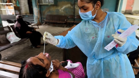 So far, 6,992 Covid-19 cases have been reported in Dharavi. In picture - A BMC health worker collects swab samples for Covid-19 test.(HT Photo)