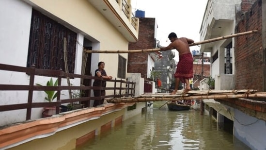 A man walks on a makeshift bamboo bridge between inundated houses following the flooding of River Ganges, in Prayagraj, Uttar Pradesh. (AP)