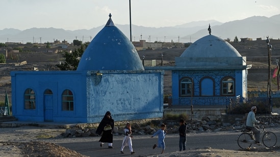 Afghanistan: People walk past a shrine in Ghazni (File Photo / AFP)