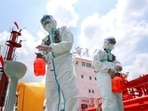 Police officers wearing protective gear against the spread of Covid-19 spray disinfectant at Nanjing port in China's eastern Jiangsu province.(AFP) Police officers wearing protective gear against the spread of Covid-19 spray disinfectant at Nanjing port in China's eastern Jiangsu province.(AFP)