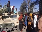 Taliban fighters stand guard along the roadside in Herat, Afghanistan's third biggest city, after government forces pulled out.