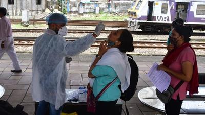 A health worker collects swab samples for Covid-19 test of passengers arriving from outstation trains at Dadar station. (HT PHOTO) A health worker collects swab samples for Covid-19 test of passengers arriving from outstation trains at Dadar station. (HT PHOTO)