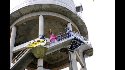 Five members of the Teacher Coordination Committee atop a water tank at Kumbhra village in Mohali. They have also threatened to commit suicide on August 15. (HT photo)