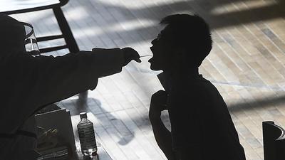 A medical worker takes a swab sample from a person in a gym during a round of Covid-19 testing in Wuhan in China's Hubei province on August 5, 2021. (AP/File)