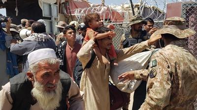 Pakistani soldiers check stranded Afghan nationals at the Pakistan-Afghanistan border crossing point in Chaman on August 13, after the Taliban took control of the Afghan border town in a rapid offensive across the country. (AFP)