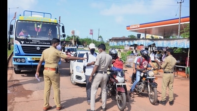 Police personnel check the COVID-19 test report of travellers at Talapady checkpost at Kerala-Karnataka border in Mangaluru. (PTI) Police personnel check the COVID-19 test report of travellers at Talapady checkpost at Kerala-Karnataka border in Mangaluru. (PTI)