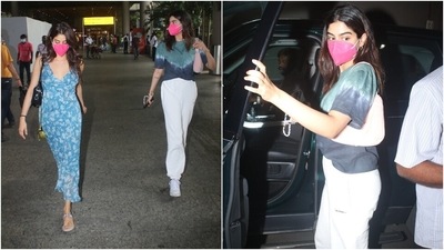 Khushi teamed her look with a small shoulder bag, pink face mask, open locks, and minimal make-up. Which sister's airport aesthetic do you like the most?&nbsp; (Varinder Chawla)