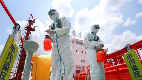 Police officers wearing protective gear against the spread of Covid-19 spray disinfectant at Nanjing port in China's eastern Jiangsu province.(AFP) Police officers wearing protective gear against the spread of Covid-19 spray disinfectant at Nanjing port in China's eastern Jiangsu province.(AFP)