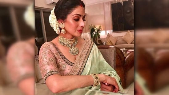 Sridevi is the epitome of royalty in this mint green Sabyasachi silk saree. She accessorised her embellished look with a potli, shimmery necklace set and big jhumkas.(Instagram/@sabyasachiofficial)