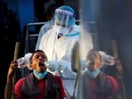 A healthcare worker collects a coronavirus disease (Covid-19) test swab sample from a man. A healthcare worker collects a coronavirus disease (Covid-19) test swab sample from a man. 