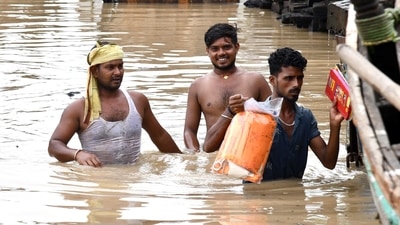 People wade through a flooded street after heavy rainfall, in Patna on Friday. The IMD has forecast fairly widespread rainfall to continue over Bihar. (ANI Photo)