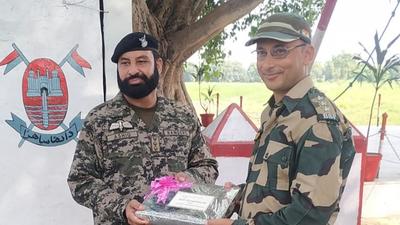 Pak Ranger and BSF official exchange sweets in RS Pura. (HT PHOTO)