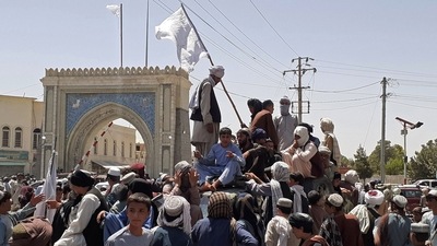 Taliban fighters stand on a vehicle along the roadside in Kandahar on Friday. (AFP Photo)
