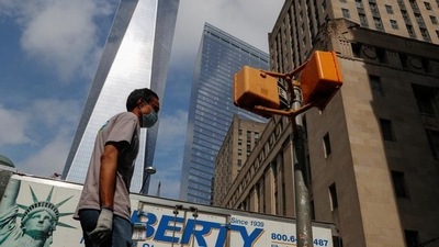 A man wearing a protective face mask walks by One World Trade Center. (Reuters file photo)
