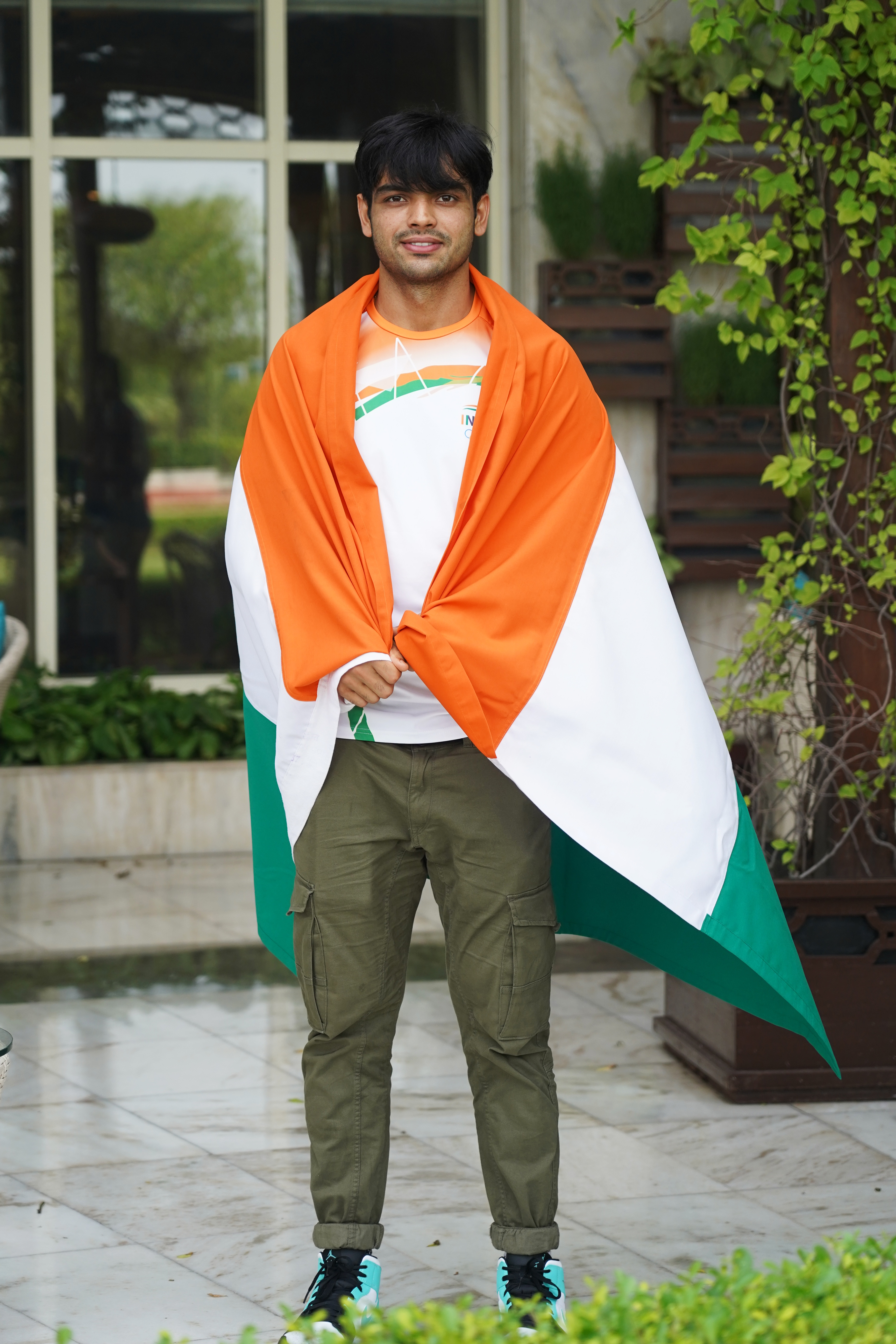 Neeraj Chopra recreated the moment from Tokyo Olympics, when he had wrapped the Indian flag around him after throwing the javelin at the finale of the Games. (Photo: Gokul VS/HT) Neeraj Chopra recreated the moment from Tokyo Olympics, when he had wrapped the Indian flag around him after throwing the javelin at the finale of the Games. (Photo: Gokul VS/HT)