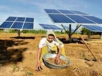 A farmer works near solar panels installed in the field to help pump water for irrigation purposes, in Gujarat’s Dhundi.&nbsp;