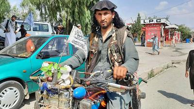 A Taliban fighter rides a motorbike through a street in Laghman province on August 15, 2021. (AFP) A Taliban fighter rides a motorbike through a street in Laghman province on August 15, 2021. (AFP)