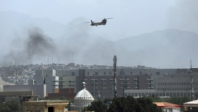 A US Chinook helicopter flies over the city of Kabul, Afghanistan, Sunday on Sunday as Taliban fighters wait at the outskirts of the capital city for a takeover. (AP) A US Chinook helicopter flies over the city of Kabul, Afghanistan, Sunday on Sunday as Taliban fighters wait at the outskirts of the capital city for a takeover. (AP)
