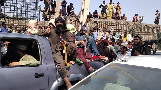 Mazar-i-Sharif and Jalalbad, the two major Afghan cities, were captured by the militants earlier on Sunday. In picture - Taliban fighters sit on a vehicle along the street in Jalalabad province.(AFP)