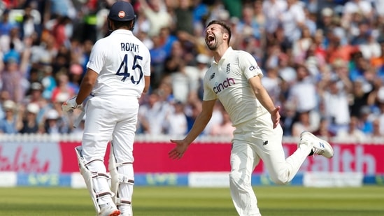 Mark Wood (R) celebrates the wicket of Rohit Sharma (L)