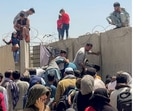 A man pulls a girl to get inside Hamid Karzai International Airport in Kabul, Afghanistan on August 16, 2021. Several photographs and videos on social media show Afghans crowding the airport trying to get out of the country after Taliban insurgents entered the capital on Sunday. (REUTERS)