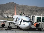 People climb atop a plane as they wait at the Kabul airport on Monday to flee Afghanistan,(AFP) People climb atop a plane as they wait at the Kabul airport on Monday to flee Afghanistan,(AFP)