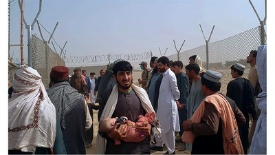 People walk through a security barrier while they enter in Pakistan through a border crossing point, in Chaman, Pakistan, Monday, Aug. 16. Normally thousands of Afghans and Pakistanis cross daily and a steady stream of trucks passes through, taking goods to land-locked Afghanistan from the Arabian Sea port city of Karachi in Pakistan.&nbsp; (AP/PTI)