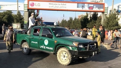 Taliban fighters on a police vehicle outside Hamid Karzai International Airport in Kabul, Afghanistan, on Monday. (Reuters Photo)