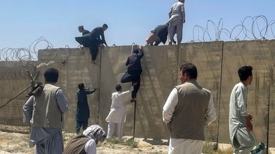 Men try to get inside Hamid Karzai International Airport in Kabul, Afghanistan on Monday (REUTERS)
