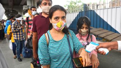 A BMC health worker check temperature of the passengers at Dadar station. (Satish Bate/HT Photo) A BMC health worker check temperature of the passengers at Dadar station. (Satish Bate/HT Photo)