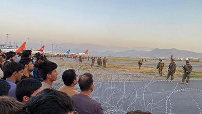 Afghan crowd at the Kabul airport as US soldiers stand guard on August 16. (AFP) Afghan crowd at the Kabul airport as US soldiers stand guard on August 16. (AFP)