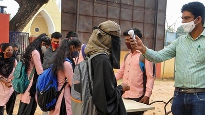 Students undergo temperature scanning as they arrive to attend classes at a school that was reopened in Chikmagalur, Karnataka. Students undergo temperature scanning as they arrive to attend classes at a school that was reopened in Chikmagalur, Karnataka.