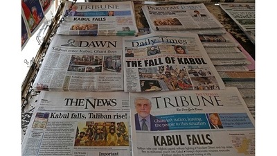Pakistan's newspapers are pictured displaying front page news about Afghanistan, at a stall in Islamabad on August 16, after the Taliban took over Afghanistan following President Ashraf Ghani’s exit.&nbsp; (Aamir Qureshi / AFP)